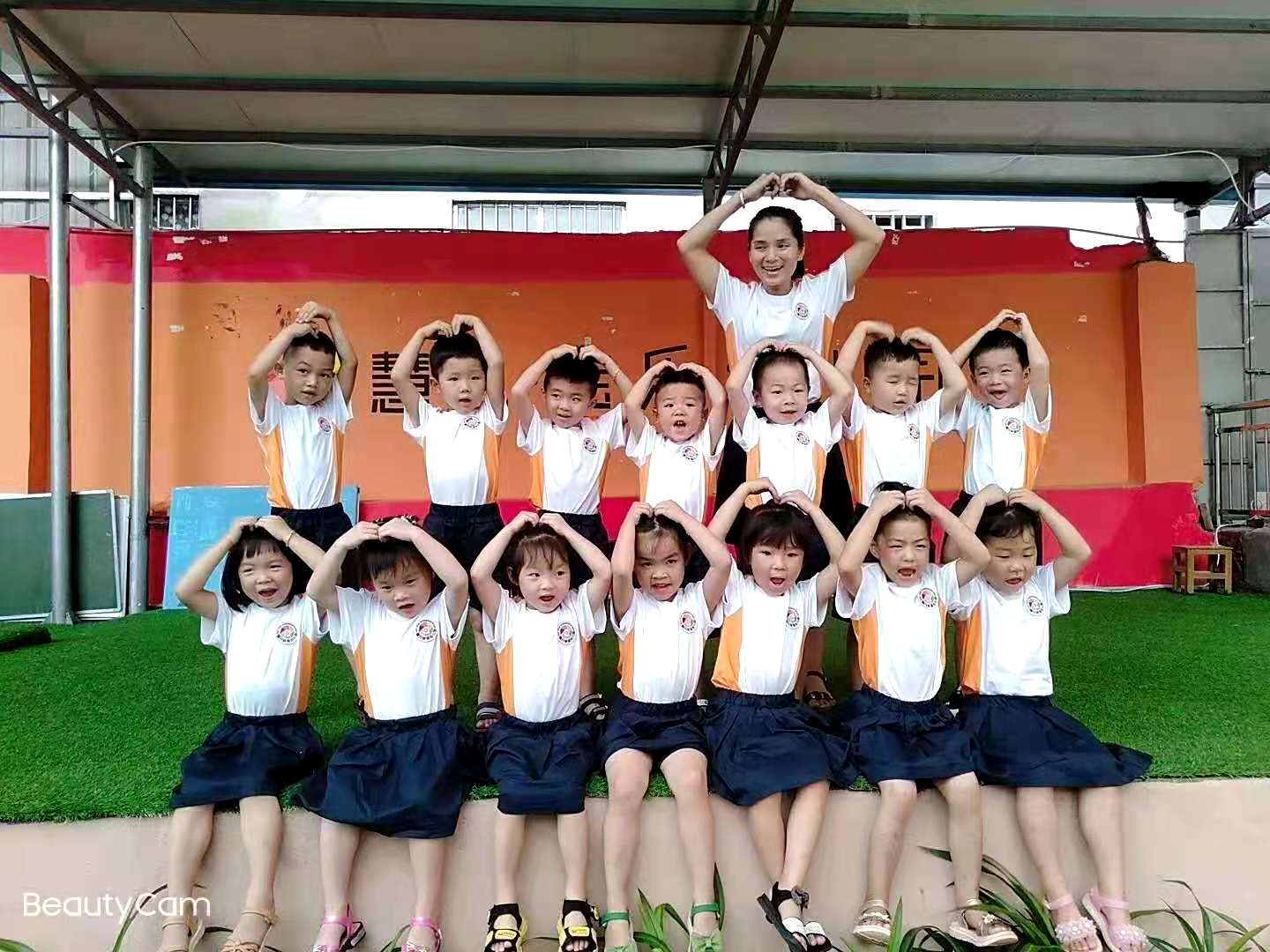 幼兒園的小朋友開(kāi)心的和老師合拍